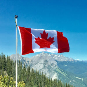 Kanadische Flagge an Fahnenmast vor Landschaft für LLP Gründung